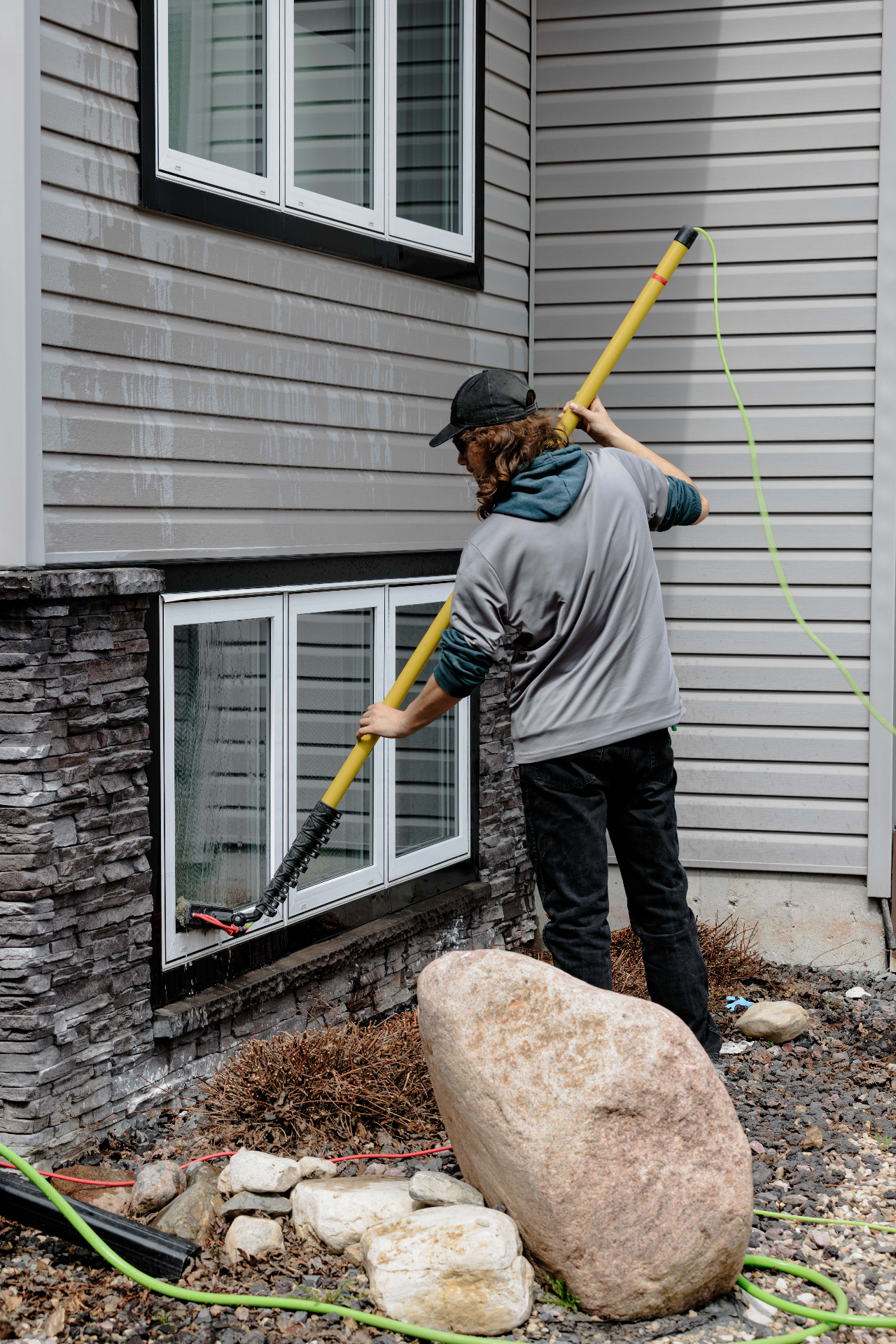 Clear Windows technician cleaning ground-level residential exterior windows